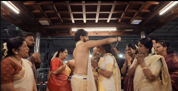 The divine moment of Thalikkettu: The groom ties the sacred mangalsutra around the bride's neck inside the traditional East Nada mandapam at Guruvayur Temple, witnessed by close family.
