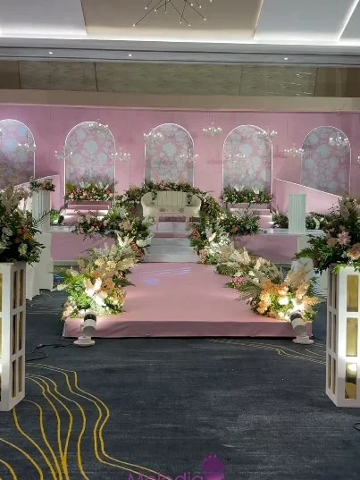 Customised stage decor in a sweet rose-pink theme, adorned with fresh flowers for Christian Destinationweding