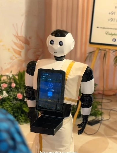 Welcome robot dressed in traditional Kerala attire at a wedding event
