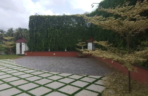 Arcadia Resort & Banquet ,High-angle view of traditional red-tiled resort roofs, central manicured lawns, and a multi-level building with a covered swimming pool area.