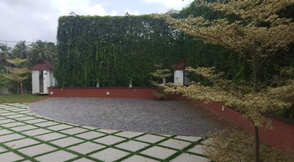 Arcadia Resort & Banquet ,High-angle view of traditional red-tiled resort roofs, central manicured lawns, and a multi-level building with a covered swimming pool area.