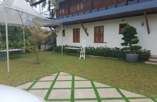 Arcadia Resort & Banquet ,Outdoor event lawn and white villa accommodation at Arcadia Resort with canopy tent setup and paved courtyard.