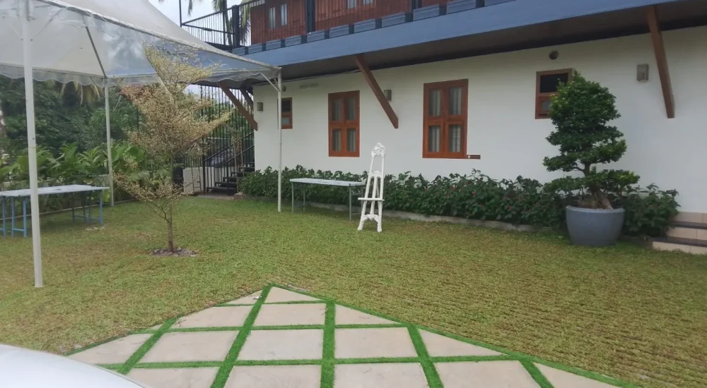 Arcadia Resort & Banquet ,Outdoor event lawn and white villa accommodation at Arcadia Resort with canopy tent setup and paved courtyard.