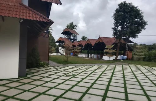 Arcadia Resort & Banquet ,High-angle view of traditional red-tiled resort roofs, central manicured lawns, and a multi-level building with a covered swimming pool area.