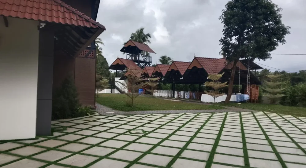 Arcadia Resort & Banquet ,High-angle view of traditional red-tiled resort roofs, central manicured lawns, and a multi-level building with a covered swimming pool area.