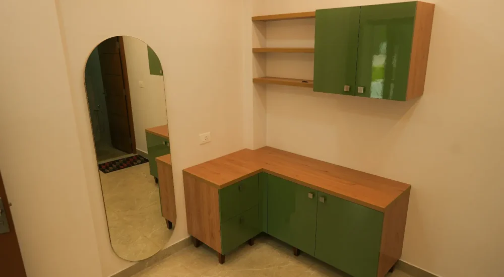 Spacious AC green room with full-length mirror and green vanity counter at Coconut Groves wedding venue.