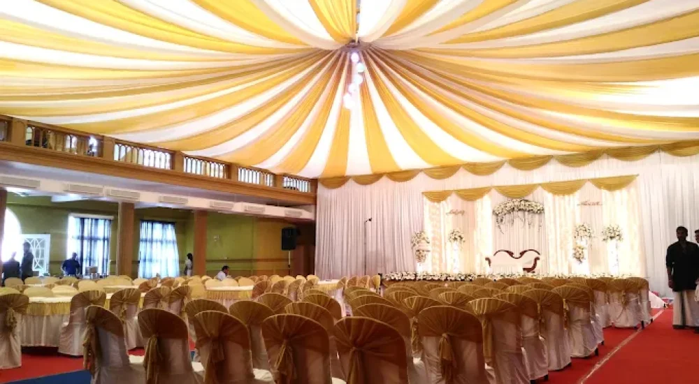 DD Retreat in Ernakulam is a spacious and well-equipped event venue ideal for grand celebrations, including weddings, receptions, and corporate functions. With a total guest capacity of up to 1,000, the venue offers both indoor and outdoor spaces to suit diverse event preferences. The indoor hall, priced at ₹1,10,000, provides a comfortable and elegant setting, while the outdoor area, available at ₹70,000, is perfect for open-air functions under the sky. The property also features ample parking space for up to 400 vehicles, ensuring hassle-free convenience for guests.