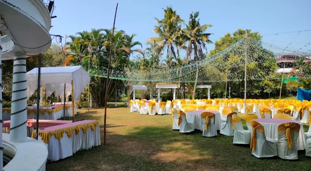 DD Retreat in Ernakulam is a spacious and well-equipped event venue ideal for grand celebrations, including weddings, receptions, and corporate functions. With a total guest capacity of up to 1,000, the venue offers both indoor and outdoor spaces to suit diverse event preferences. The indoor hall, priced at ₹1,10,000, provides a comfortable and elegant setting, while the outdoor area, available at ₹70,000, is perfect for open-air functions under the sky. The property also features ample parking space for up to 400 vehicles, ensuring hassle-free convenience for guests.