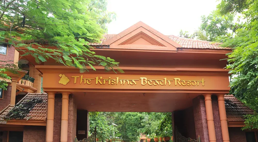 Main gate and welcoming archway of Krishna Beach Resort with traditional Vaasthu Shilpa wooden elements.