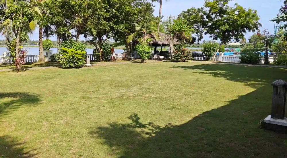 Sunlit open-air venue lawn and palm-lined grounds at Indriya Sands destination wedding resort near Kuzhupilly Beach, Kochi.