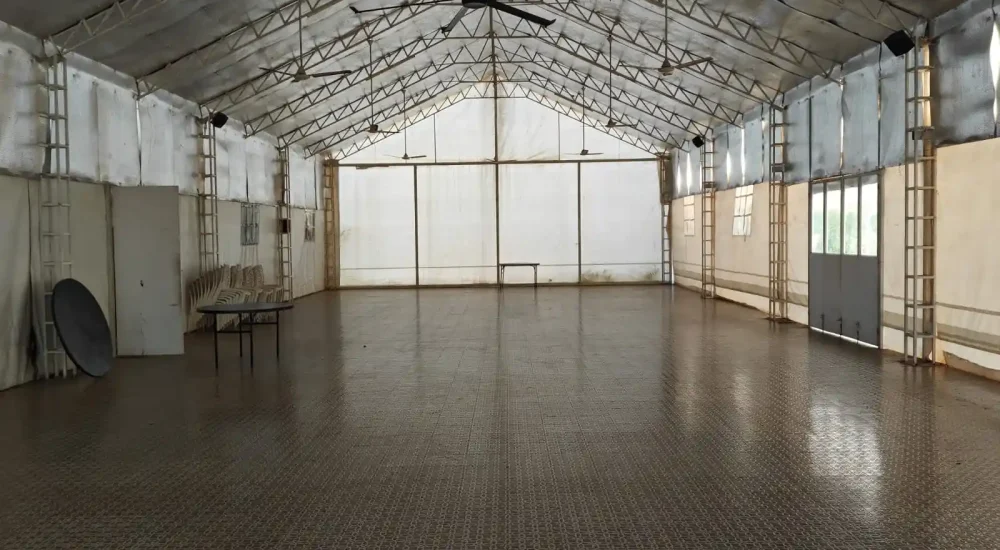 Column-free traditional Kerala-style indoor event hall at Indriya Sands destination wedding resort near Kuzhupilly Beach, Kochi, with wooden ceiling and floor.