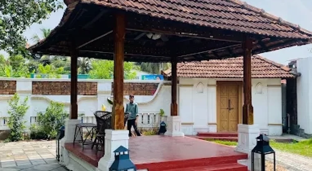 Fixed stage platform with traditional wooden backdrop for wedding events at Kumarakom Tharavadu