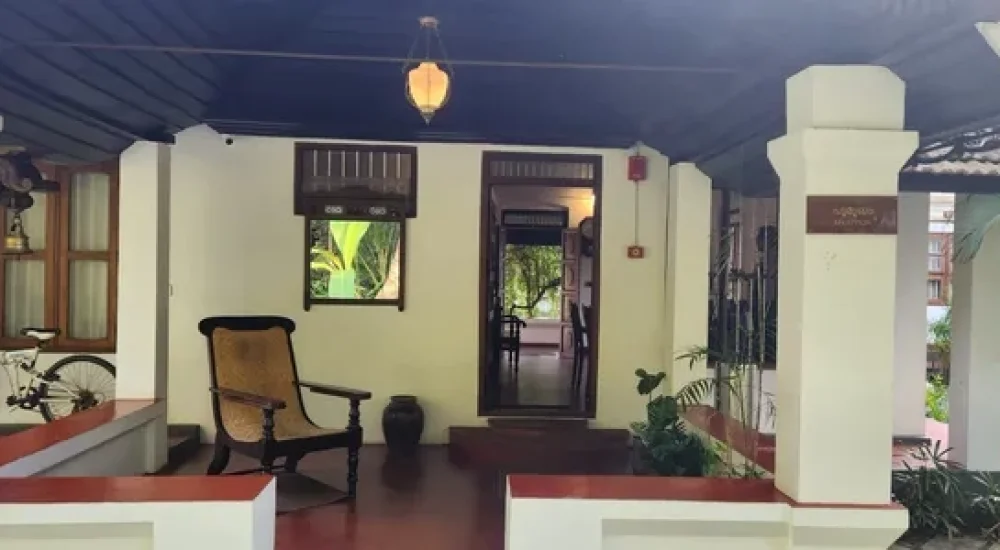 Air-conditioned indoor dining hall set up with round tables and banquet seating at Kumarakom Tharavadu