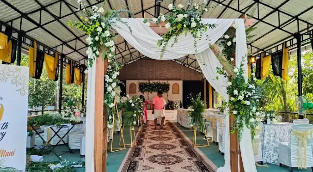 eautifully illuminated event entrance archway at Mankara Farms featuring hanging fairy lights, warm string lighting, and cascading floral architecture designed by Melodia Event Management.