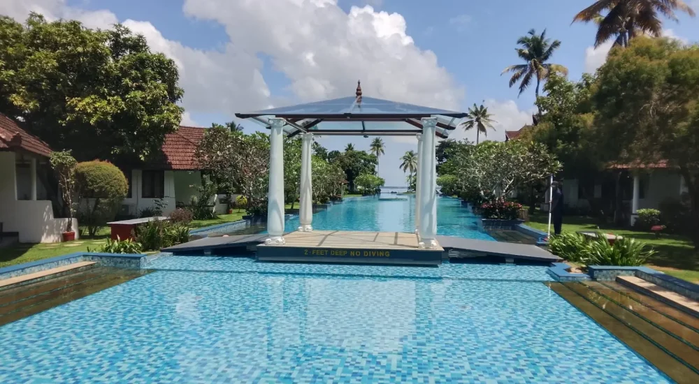 Longest swimming pool in India with central white gazebo pavilion at Rhythm Kumarakom destination wedding resort