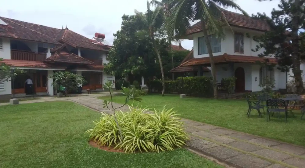 Relaxing lawn seating area with lounge sunbeds and panoramic Vembanad Lake views at Backwater Ripples Hotel Kumarakom.