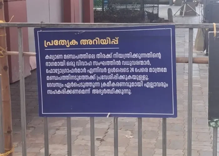 Notice board outside Guruvayur Temple wedding mandapam stating a maximum limit of 24 persons per wedding group, including bride, groom, and photographers.